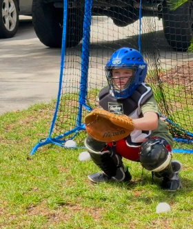 Cash crouched behind the plate in full catcher's gear